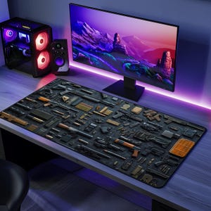 Puede incluir: Alfombrilla de escritorio negra con una disposición detallada de varias armas de fuego, municiones y equipos relacionados. La alfombrilla está colocada sobre un escritorio de madera, con un monitor de ordenador, un altavoz y una torre de ordenador en el fondo.