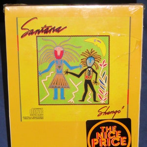 May include: A yellow CD case with a colorful illustration of two figures on the front. The case is titled "Santana Shango" and features a sticker that reads "The Nice Price". The back of the case lists the songs on the CD.