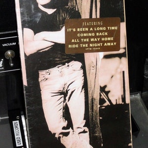 Puede incluir: Portada de álbum en blanco y negro de Southside Johnny & the Asbury Jukes, titulada "Better Days". La portada presenta a un hombre con gafas de sol y vaqueros. El álbum incluye las canciones "It's Been a Long Time" y "Coming Back".