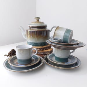 May include: A vintage tea set with a brown, white and blue glaze. The set includes a teapot, four cups and four saucers.