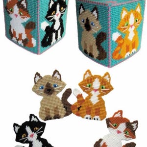 May include: Handmade tissue box covers in a teal color, featuring colorful cat designs. The cats are in various colors, including orange, black, brown, and white. The tissue boxes are square and have a top opening for tissues.