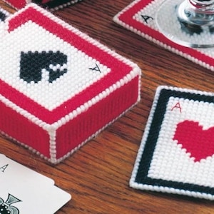 Pode incluir: Um conjunto de quatro  costuras de crochê com designs de cartas de jogar. Os  costuras são brancos com detalhes vermelhos e pretos. Os designs incluem um ás de paus, um ás de copas e dois ases de ouros. Os  costuras são perfeitos para proteger as superfícies do calor e dos derramamentos.