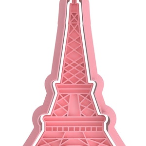 Op de afbeelding: Roze plastic koekjesvormpje in de vorm van de Eiffeltoren.