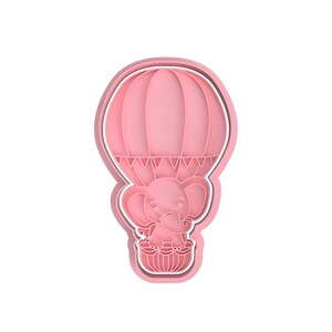 Puede incluir: Cortador de galletas de plástico rosa en forma de globo aerostático con un elefante dentro.