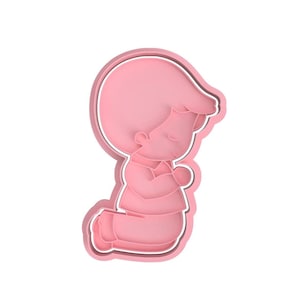 Può includere: Tagliapasta in plastica rosa a forma di bambino inginocchiato in preghiera con le mani giunte.