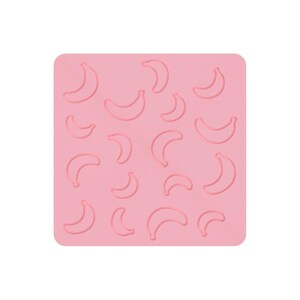 May include: A pink silicone mold with multiple banana outlines. The banana shapes are evenly spaced across the surface. The mold is square with rounded corners.