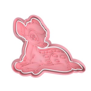 Può includere: Tagliabiscotti in plastica rosa a forma di cervo sdraiato. Il tagliabiscotti ha un contorno bianco e dettagli precisi, tra cui orecchie, occhi e macchie del cervo. Ideale per la pasticceria.