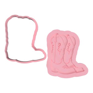 Può includere: Set di tagliabiscotti e stampo rosa a forma di stivali da cowboy. Il tagliabiscotti è un semplice contorno, mentre lo stampo presenta dettagliati disegni di stivali. Ideale per creare biscotti o decorazioni a tema.