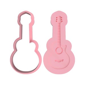 Peut inclure: Deux emporte-pièces roses en forme de guitare. L'un est un contour, l'autre présente des détails intérieurs comme le trou de son, les cordes et les chevilles d'accord. Les emporte-pièces sont en matériau opaque.