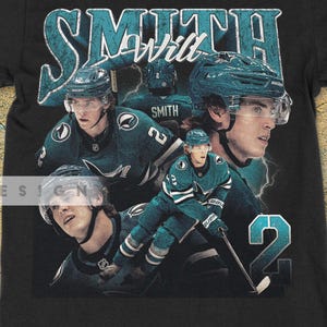 Puede incluir: Camiseta negra con un diseño en verde azulado y blanco que presenta a un jugador de hockey llamado Smith y el número 2. La camiseta tiene un aspecto vintage y desgastado.