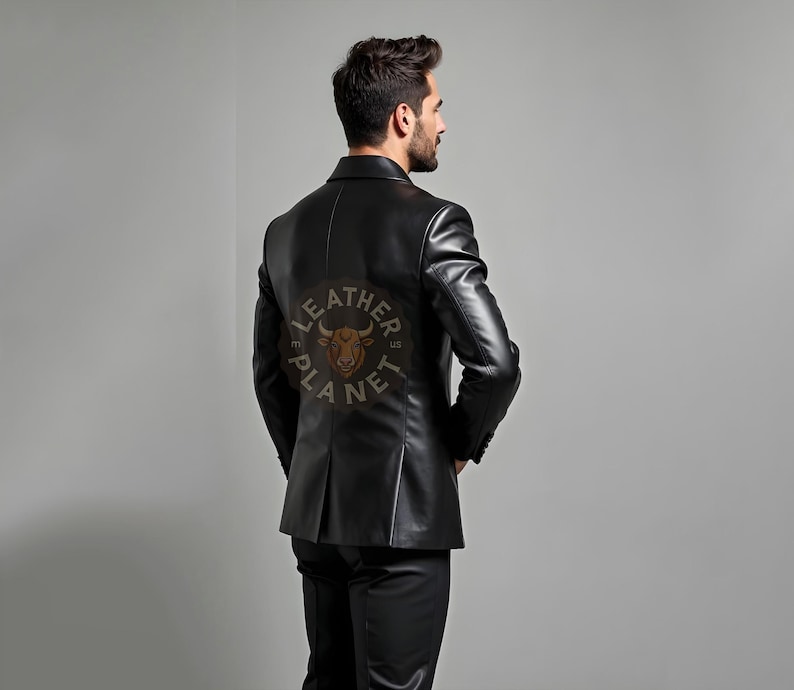 Pu&ograve; includere: Un blazer in pelle nera dal design classico. Il blazer presenta una vestibilit&agrave; sartoriale, revers a lancia e chiusura a due bottoni. La parte posteriore del blazer presenta un logo circolare con la scritta "LEATHER PLANET". Il modello indossa pantaloni neri.