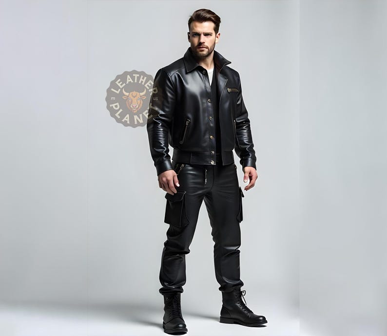 May include: A black leather jacket with a zipper closure and a button-up front. The jacket has a stand-up collar and two pockets on the front. The model is wearing black leather pants with a zipper detail on the front.