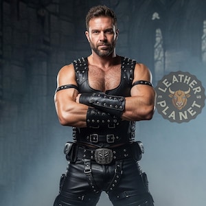Könnte beinhalten: Schwarze Lederweste mit Nieten, passenden Armbändern und fingerlosen Handschuhen. Die Weste wird mit einer schwarzen Lederhose und einer dekorativen Gürtelschnalle kombiniert. Das Bild enthält das Logo "Leather Planet US".