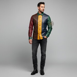 May include: A multi-colored leather shirt with long sleeves. The shirt features panels of burgundy, brown, yellow, navy, and green. The model is wearing black jeans and black boots.