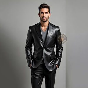 Pu&ograve; includere: Un blazer in pelle nera con chiusura a due bottoni, abbinato a pantaloni neri coordinati. Il blazer presenta revers a lancia e due tasche frontali. Il modello indossa una maglietta grigia con scollo a V. L'aspetto generale &egrave; elegante e moderno.