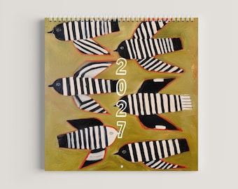 May include: A spiral-bound wall calendar featuring a painted olive green background with six stylized birds. Each bird has black and white vertical stripes and thin orange outlines. The year 2027 is printed in white text vertically in the center.