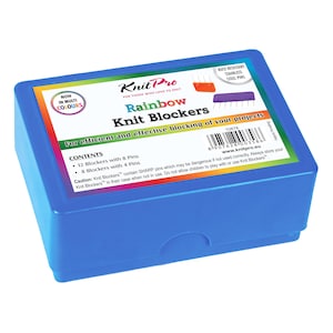Peut inclure: Une boîte en plastique bleue contenant des Knit Blockers Rainbow de Knit Pro. La boîte a une étiquette colorée avec du texte et des illustrations. L'étiquette indique "Pour un blocage efficace de vos projets". La boîte contient 12 bloqueurs avec 8 broches et 8 bloqueurs avec 4 broches.