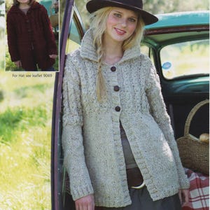 May include: A woman wearing a light beige knitted cardigan with a shawl collar and large brown buttons. The cardigan is paired with a brown hat. The image also includes a smaller image of a child wearing a burgundy knitted coat. The text "For Hat see leaflet 9069" is visible.