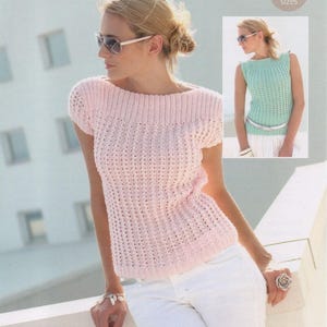 May include: A pale pink, short-sleeved, knitted top with a boat neck. The top features a textured stitch and is worn with white trousers. A smaller image shows a similar sleeveless top in a light green colour. The text "Includes larger sizes" is in the upper right corner.