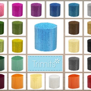 Puede incluir: Una colección de rollos de hilo coloridos en varios tonos, incluyendo rosa, morado, azul, verde, amarillo, marrón, gris, negro, naranja y blanco. La imagen incluye un rollo de hilo azul central y un letrero que dice "Trimits".