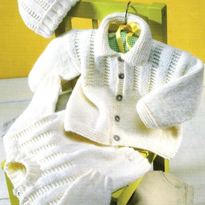 May include: A white knitted baby outfit consisting of a cardigan, trousers, and a hat. The outfit is crafted with a fine stitch pattern and features button fastenings.
