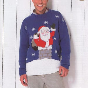 Puede incluir: Suéter azul de punto con un patrón de copo de nieve blanco y un diseño de Papá Noel rojo y blanco. Papá Noel lleva una bolsa de regalos y está bajando por una chimenea.