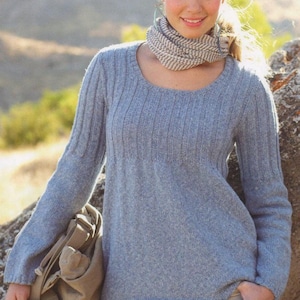 May include: A light blue knitted jumper with a scoop neck and long sleeves. The jumper is made from a soft, textured yarn and has a relaxed fit.