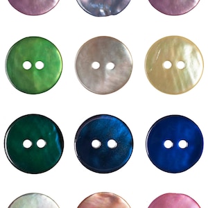 Puede incluir: Una colección de doce botones redondos en varios colores, incluyendo morado, azul, verde y dorado. Cada botón tiene dos agujeros y un brillo nacarado, lo que sugiere que están hechos de nácar. Adecuados para proyectos de costura y artesanía.