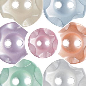May include: Seven decorative buttons in pastel shades. Each button features a flower-shaped design with six curved petals and two sewing holes. Colours include beige, light blue, lavender, pink, orange, green, and white.