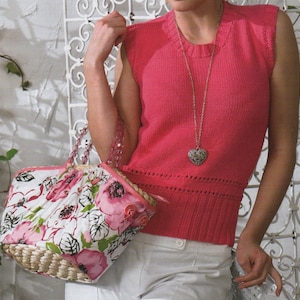 Może przedstawiać: Różowy, bezrękawnikowy sweterek z naszyjnikiem z serduszkowym wisiorem i torbą z kwiatowym wzorem.