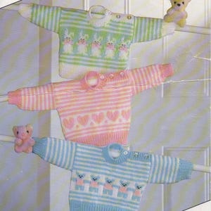 Peut inclure: Trois pulls pour bébés tricotés dans des tons pastel. Le pull du haut est à rayures vertes et blanches avec des motifs de lapins. Le pull du milieu est à rayures roses et blanches avec des motifs de cœurs. Le pull du bas est à rayures bleues et blanches avec des motifs d'ours.