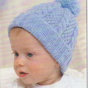 May include: A light blue knitted baby hat with a cable knit design and a pom-pom on top. The hat is worn by a baby with fair skin and blue eyes, wearing a white shirt. The hat is a soft, cozy accessory.