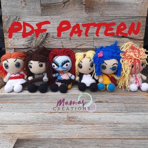 May include: PDF pattern for crocheting six different amigurumi dolls. The dolls are all in a sitting position and have large eyes. The dolls are dressed in various outfits, including a red dress, a black and white dress, a blue and yellow dress, a white dress, and a yellow dress. The dolls are all sitting on a wooden surface.