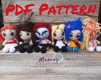 Könnte beinhalten: PDF-Muster zum Häkeln von sechs verschiedenen Amigurumi-Puppen. Die Puppen sitzen alle und haben große Augen. Die Puppen sind in verschiedenen Outfits gekleidet, darunter ein rotes Kleid, ein schwarz-weißes Kleid, ein blau-gelbes Kleid, ein weißes Kleid und ein gelbes Kleid. Die Puppen sitzen alle auf einer Holzoberfläche.