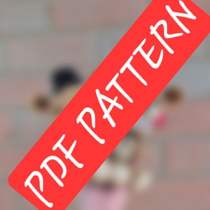 May include: A digital document featuring the text PDF PATTERN in white capital letters on a red rectangular background, positioned diagonally across a blurred, out-of-focus image of a small, light-colored object with dark brown accents.