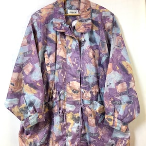 Może przedstawiać: Kurtka w stylu vintage z abstrakcyjnym wzorem w odcieniach fioletu, błękitu i brzoskwini. Kurtka ma kołnierz, długie rękawy i talię ze sznurkiem. Posiada zapięcie na guziki i dwie przednie kieszenie.