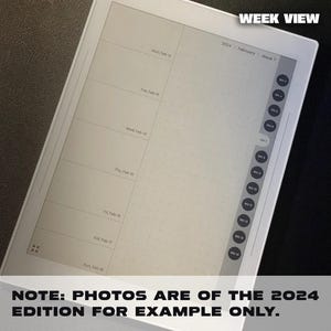 May include: A white e-reader with a black screen displaying a weekly calendar view for February 2024. The screen shows the days of the week, Monday through Sunday, with the dates for each day. The text "WEEK VIEW" is displayed at the top of the screen. The text "2024 February Week 7" is displayed below the "WEEK VIEW" text. The text "NOTE: PHOTOS ARE OF THE 2024 EDITION FOR EXAMPLE ONLY." is displayed at the bottom of the screen.
