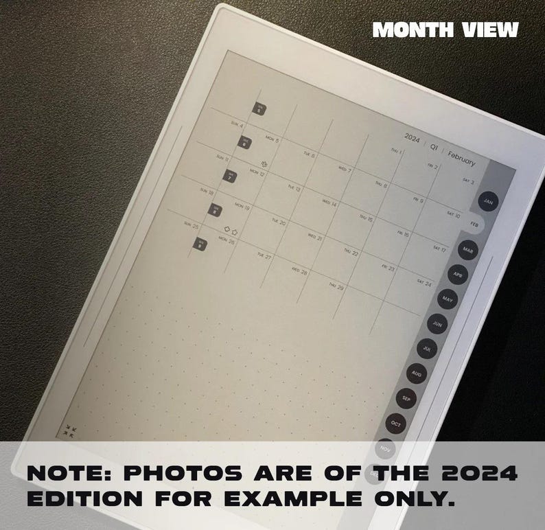 May include: A white e-reader with a monthly calendar view for the year 2024. The calendar is displayed on the screen, with the month of February highlighted. The screen is blank, except for the calendar and the text "MONTH VIEW" at the top.