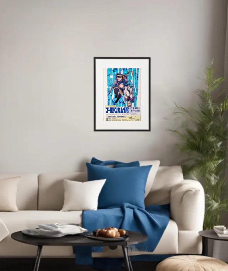 May include: Framed poster with a vibrant anime-style illustration and Japanese text. The artwork shows two characters in dynamic poses against a blue and white backdrop. The poster is mounted on a white wall above a beige sofa with blue cushions.
