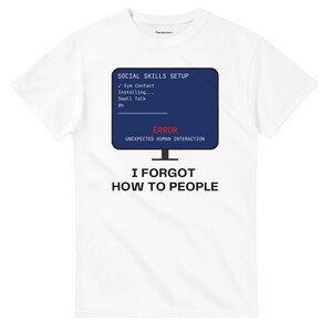 Może przedstawiać: Biały t-shirt z krótkim rękawem z grafiką monitora komputerowego wyświetlającego niebieski ekran z tekstem SOCIAL SKILLS SETUP, Eye Contact, Installing, Small Talk, 0%, ERROR, UNEXPECTED HUMAN INTERACTION oraz I FORGOT HOW TO PEOPLE.