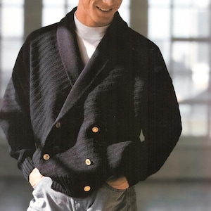 Puede incluir: Un cárdigan de punto negro con cuello chal y botones dorados. El cárdigan es de doble botonadura y tiene una textura acanalada.