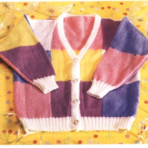 May include: A multi-colored knitted cardigan with a V-neck and button closure. The cardigan is made in a patchwork style with squares of pink, yellow, purple, and blue.