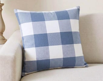 May include: A square throw pillow featuring a classic buffalo check pattern in shades of blue and white. The fabric displays a repeating grid of large, alternating blue and white squares, creating a balanced and uniform geometric design across the surface.