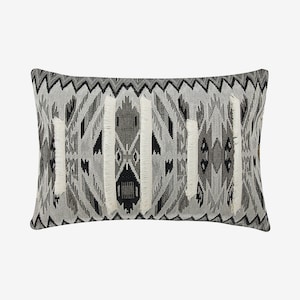 May include: Black and white patterned throw pillow with fringe trim. The pillow has a geometric design with black, white, and gray colors.