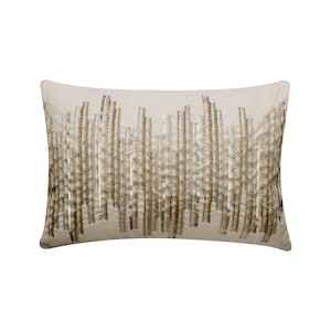 May include: A beige rectangular pillow with a decorative pattern of gold and silver sequins arranged in vertical lines.