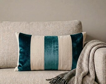 May include: A rectangular throw pillow featuring a striped pattern of alternating teal velvet and beige linen-textured fabric panels. The pillow has a smooth, soft appearance with distinct vertical color blocking and clean, straight stitched seams.