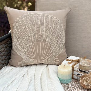 Capa de almofada decorativa estilo praia em algodão e linho bege mocha com estampa de criaturas marinhas e miçangas - Concha de vieira