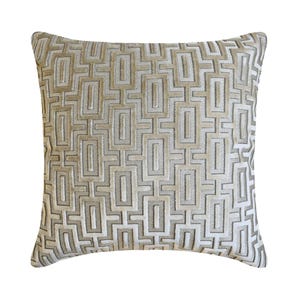May include: Square cushion with a geometric pattern in beige, cream, and grey. The design features a repeating rectangular motif, creating a textured appearance. The cushion is likely for home decor.