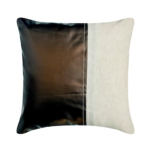 May include: A square throw pillow featuring a two-tone design. The left side is made of a dark, metallic bronze-brown fabric with a smooth, reflective finish, while the right side is a light beige, textured fabric separated by a vertical seam.
