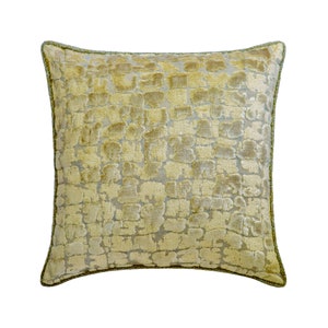 May include: A square throw pillow with a green and beige patterned fabric. The pillow has a green trim around the edges.